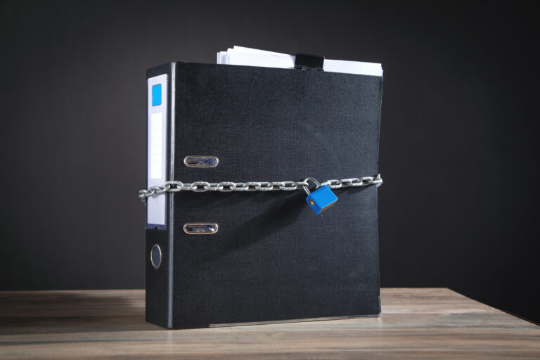 Dokumenty w segregatorze zamknięte na kłódkę